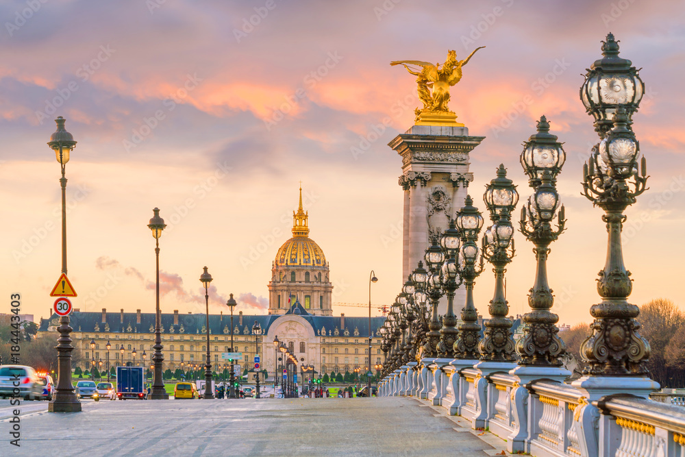 Most Aleksandra III z widokiem na Les Invalides o zachodzie słońca w Paryżu