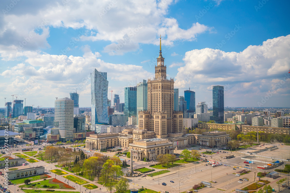 Dzień w Warszawie, panorama miasta z Pałacem Kultury i Nauki oraz nowoczesnymi wieżowcami, błękitne niebo.