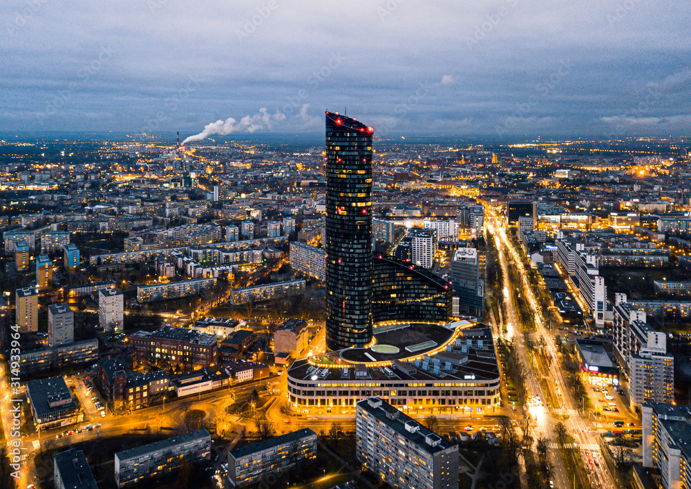 Nocna panorama Wrocławia z widokiem na Sky Tower i rozświetlone miasto, ujęcie z drona