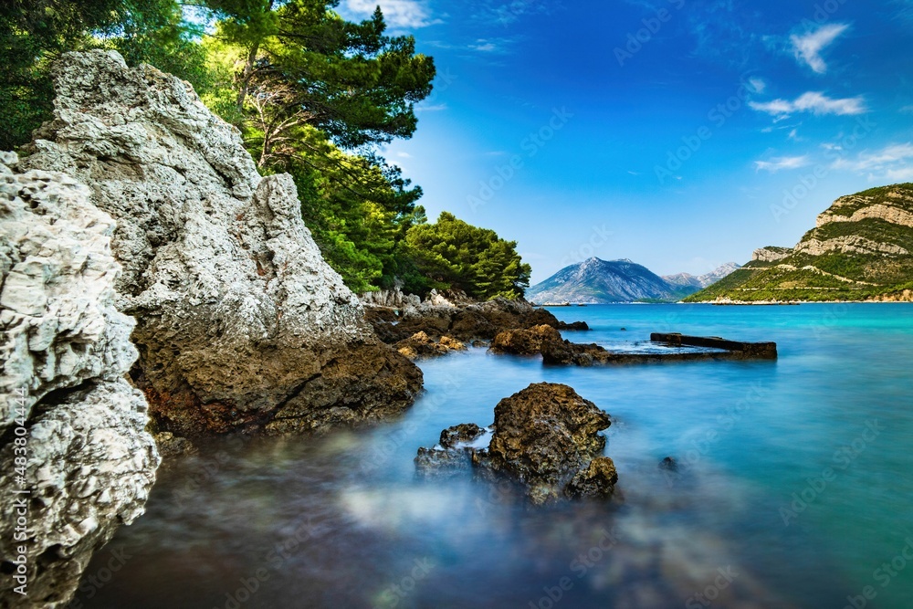 Obraz na płótnie przedstawiający chorwackie wybrzeże z kamienną plażą i turkusowym morzem, idealny do wnętrz mediterraneńskich i nadmorskich.