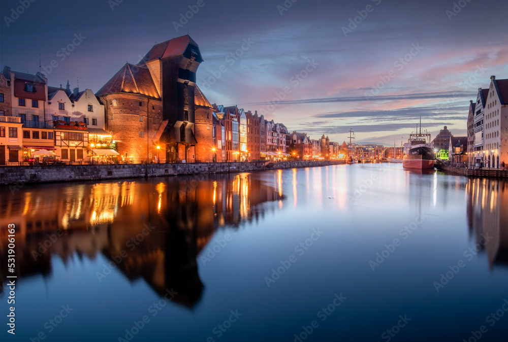 Gdańsk nocą, Długie Pobrzeże, Żuraw, odbicia w Motławie, oświetlone kamienice, styl miejski.