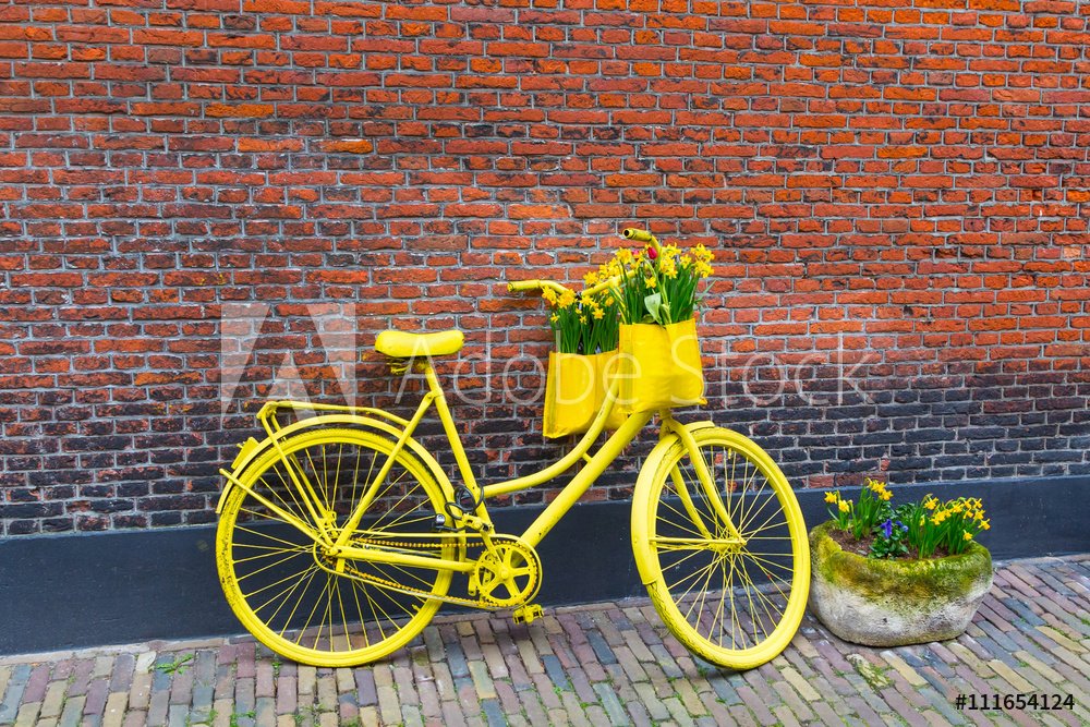 Zółty rower z koszem kwatów